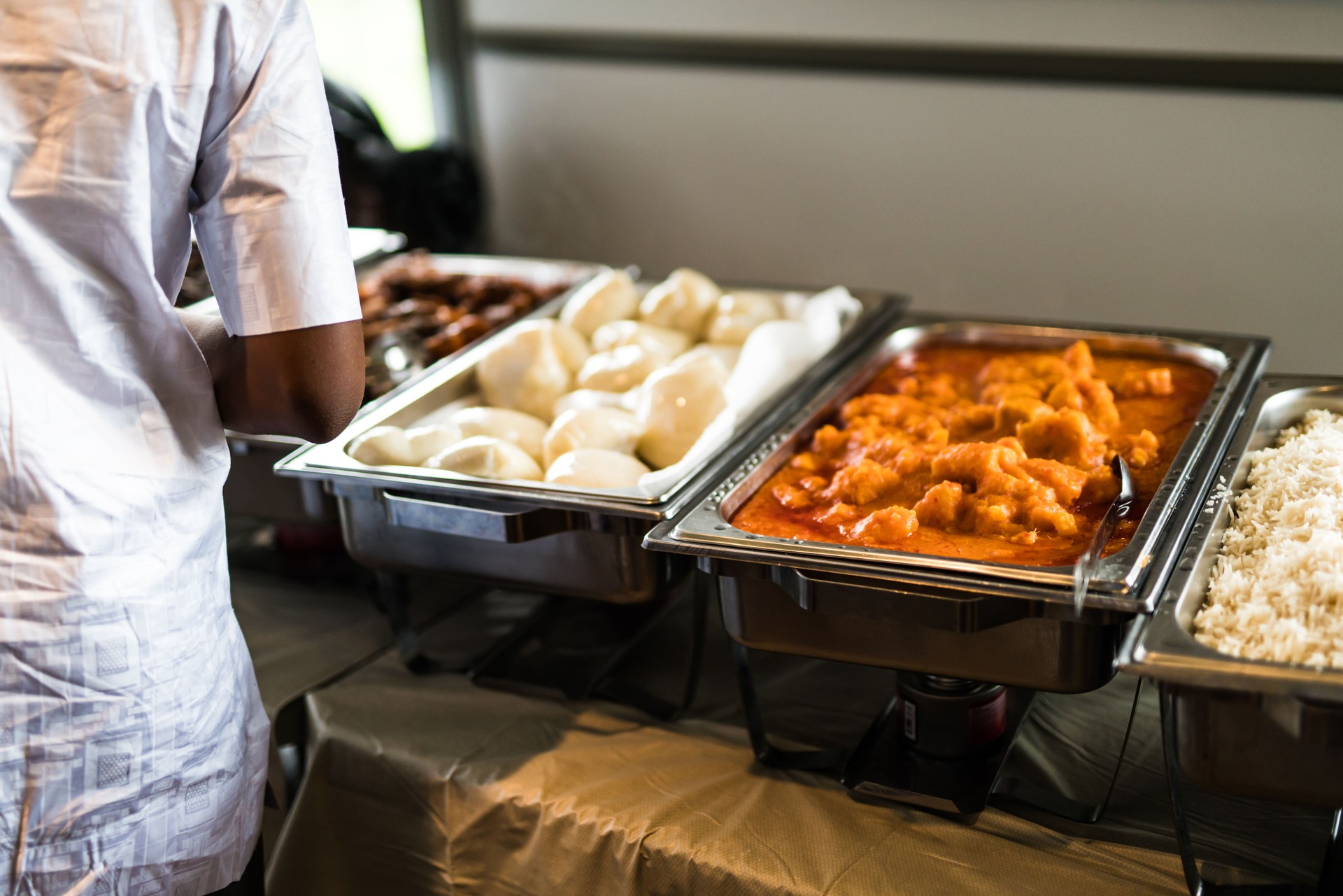 Plates and Chaffing Dishes set up for Nigerian Party Buffet